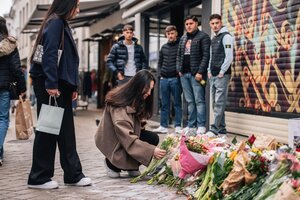 Eine Frau legt einen Blumenstrauß am Gedenkort in der Oldenburgischen Fußgängerzone nieder