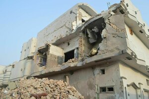 Nach einem Bombenangriff zerstörtes Gebäude, vor dem ein Haufen Schutt liegt
