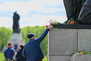 Mann legt Blume auf einen Sockel