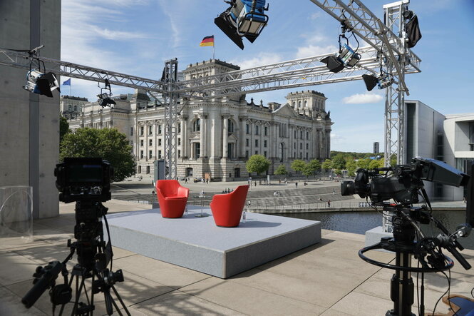 Zwei leere rote Sessel stehen für eine TV-Produktion vor dem Reichstag in Berlin