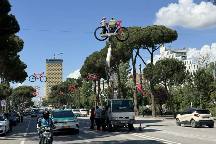 Arbeiter befestigen an Seilen über der Straße Rennrad-Imitate