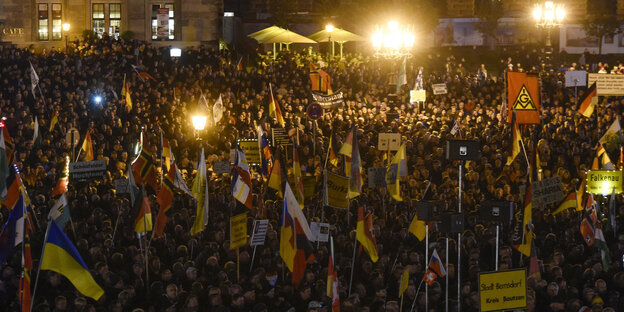 Eine große Gruppe Pegida-Nazis mit ihren Banner und Flaggen und Hohlköpfen