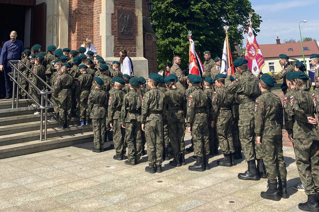 Schlange Uniformierter vor einer Kirche.