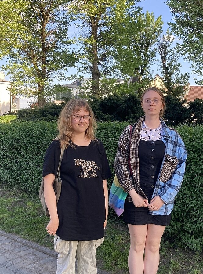 Michalina und Kate stehen nebeneinander auf einem Gehweg