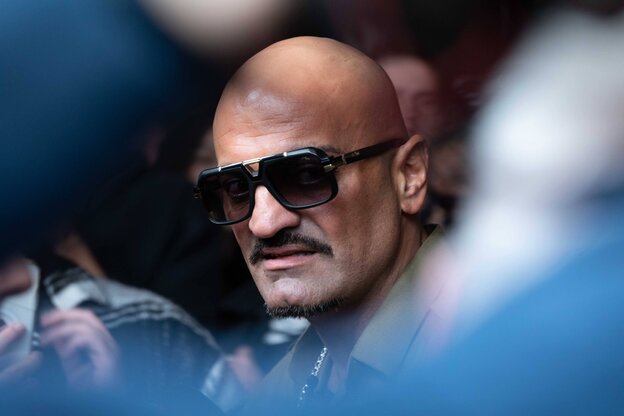 Ein Mann mit Sonnenbrille schaut grimmig