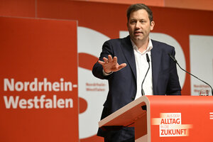 Mann gestikuliert von Rednerpult aus