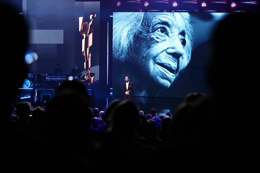 Igor Levit auf der Bühne vor einem großen Foto von Margot Friedländer