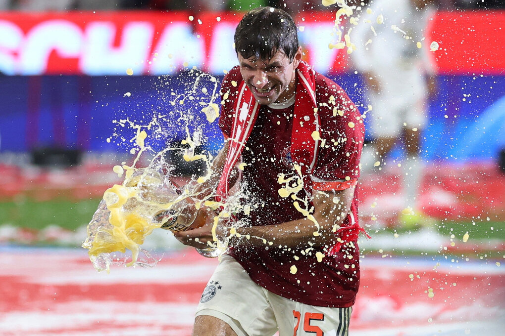 Thomas Müller rennt mit einem Bierglas, aus dem das Bier spritzt