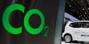 Ein Auto auf einer Messe vor einem Schild, auf dem CO2 steht