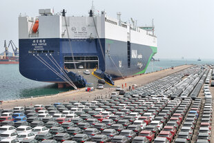 Zu sehen ist ein Frachtschiff im Hafen von Yantai, das unzählige Autos auflädt.