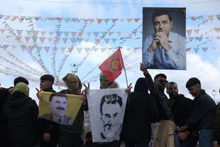 Menschen halten ein Plakat von Selahattin Demirtas, dem inhaftierten ehemaligen Vorsitzenden der prokurdischen Demokratischen Volkspartei (HDP), und Bilder des Kurdenführers Abdullah Öcalan während des Frühlingsfestes Newroz in Diyarbakir im Südosten der Türkei, 21. März 2025