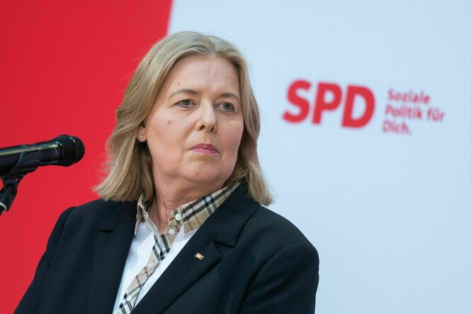 Eine Frau am Rednerpult schaut ernst