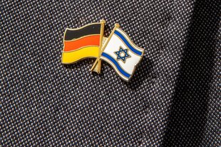 Ein Deutschlandfähnchen und ein Israelfähnchen am Revers eines Herrenjackets