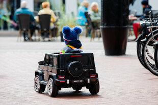 Kleiner Junge fährt in einem Mini-Elektroauto herum.