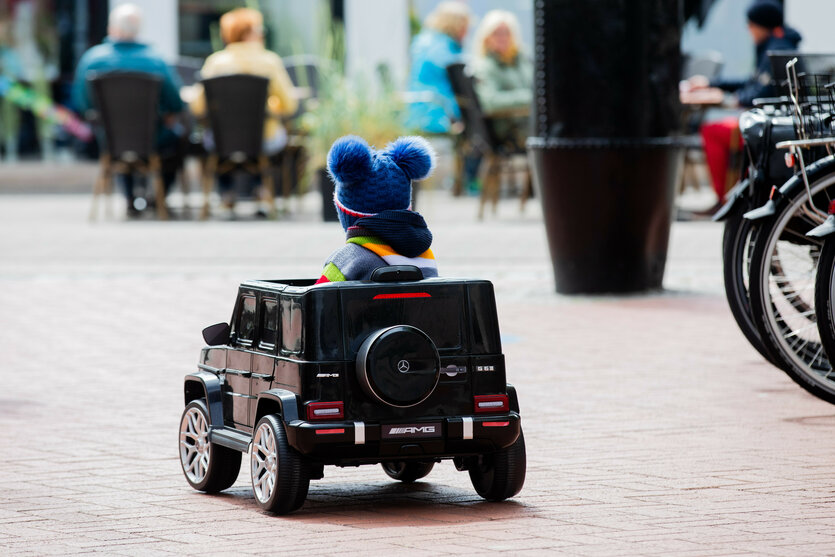 Kleiner Junge fährt in einem Mini-Elektroauto herum.