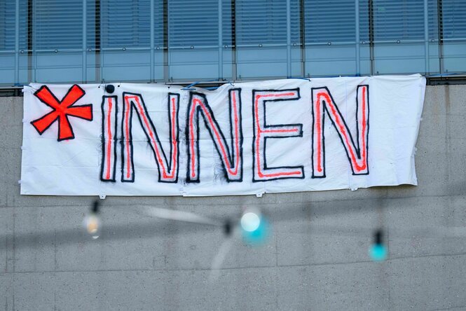 Ein Plakat mit der Aufschrift „*Innen“ ist an der Hochschule für Fernsehen und Film München (HFF) zu sehen
