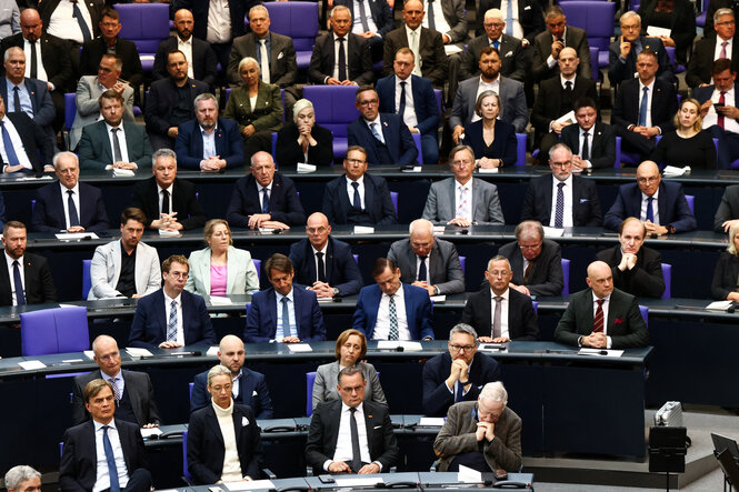 Menschen sitzen im Bundestag