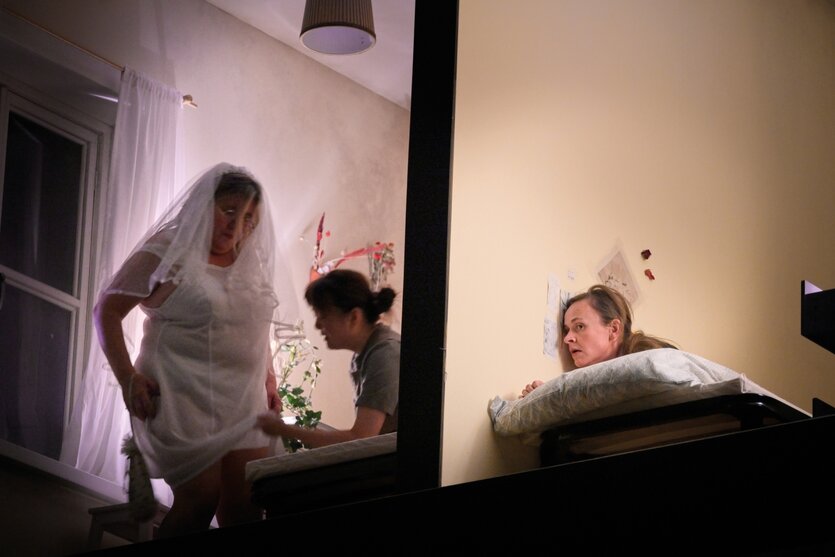 Drei Frauen in einem Durcheinander auf einer Theaterbühne