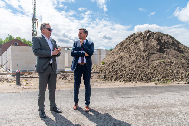 Olaf Lies, mit Sonnebrille, und Jürgen Krogmann stehen vor einem Erdhaufen
