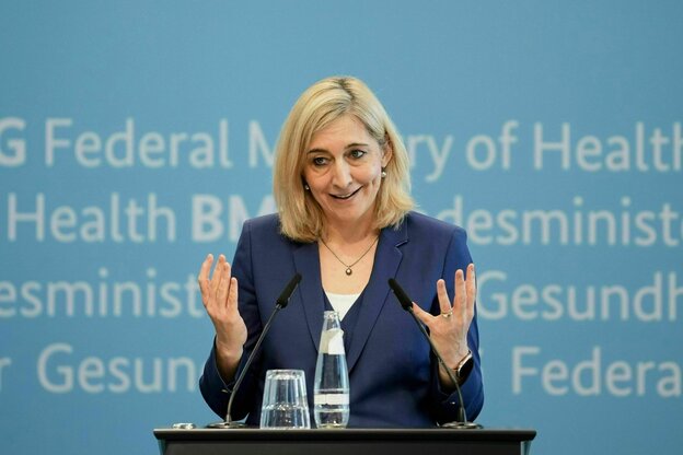 Eine Frau gestikukliert an einem Rednerpultund spricht in die Mikrofone
