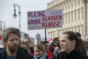 Lehrkräfte nehmen an einem Warnstreik in Berlin teil und halten ein Plakat mit der Aufschrift "Kleine Klassen - große Klasse" hoch