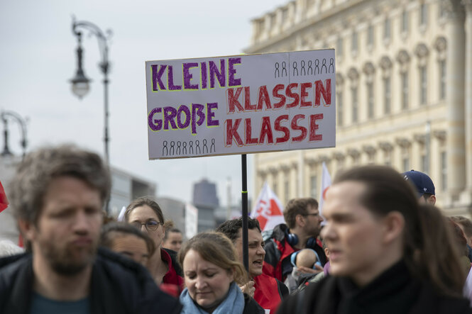 Lehrkräfte nehmen an einem Warnstreik in Berlin teil und halten ein Plakat mit der Aufschrift "Kleine Klassen - große Klasse" hoch