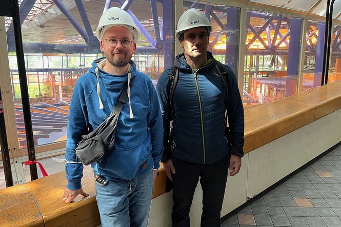 Zwei Männer mit Helm stehen bei einem Rundgang durch das leerstehende SEZ für ein Foto zusammen