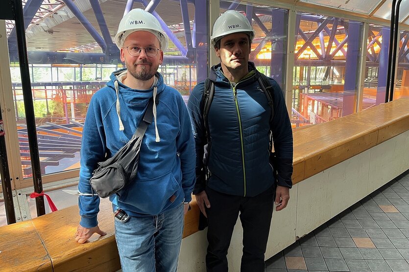 Zwei Männer mit Helm stehen bei einem Rundgang durch das leerstehende SEZ für ein Foto zusammen