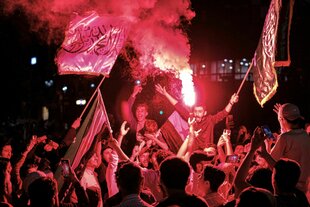 Menschen jubeln und zünden Pyrotechnik