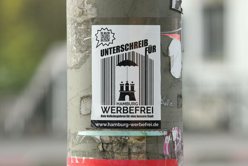Sticker der Volksinitiative "Hamburg werbefrei" an einem Laternenmasten