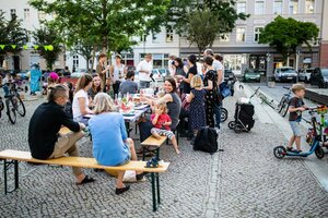 Menschen sitzen auf Bierbänken