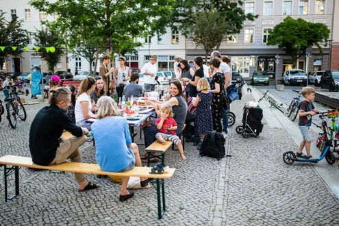Menschen sitzen auf Bierbänken