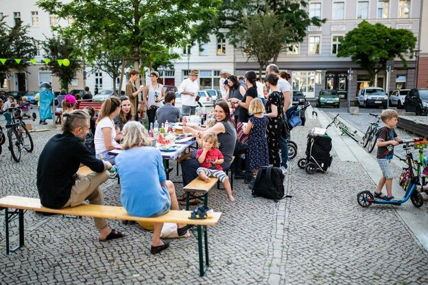 Menschen sitzen auf Bierbänken