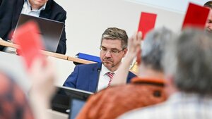 Mike Schubert sitzt Stadtverordneten gegenüber, die eine rote Karte zeigen