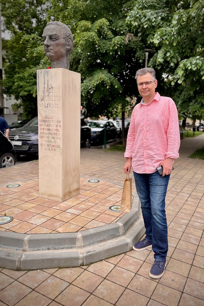 Portrait von Mihail Demetriade vor einer Statue