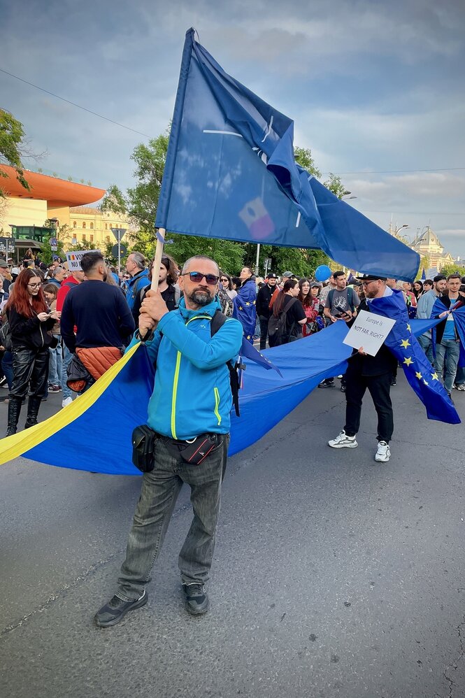 Ein mann demonstriert mit einer NATO-Fahne