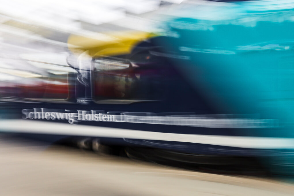 ein Zug fährt an einem Bahnsteig vorbei