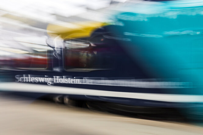 ein Zug fährt an einem Bahnsteig vorbei