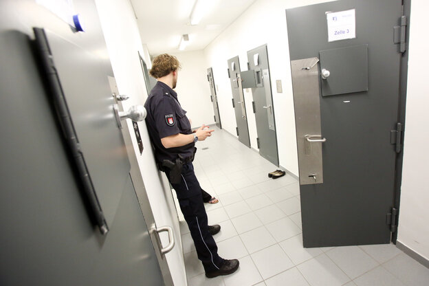 Ein Polizist in einem Zellentrakt