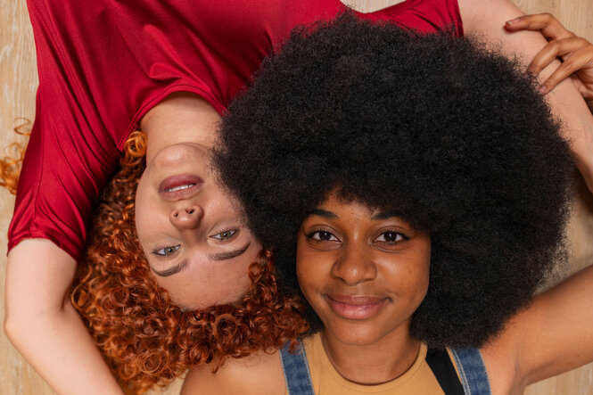 Zwei Frauen: eine mit roten, die andere mit schwarzen Haaren