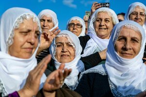 Frauen mit weißen Kopftüchern stehen zusammen und applaudieren