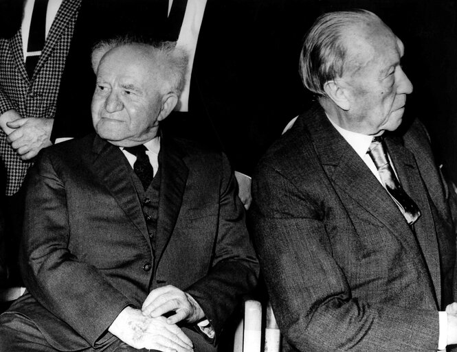 Konrad Adenauer und David Ben Gurion sitzen nebeneinander, sie wenden die Köpfe voneinander ab
