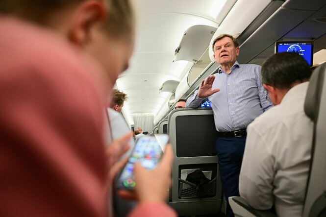 Außenminister Wadephul steht in einem Flugzeug und spricht zu Journalisten
