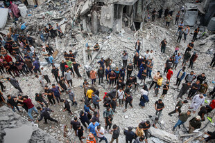 Menschen stehen in den Trümmern in Jabalia, Gaza