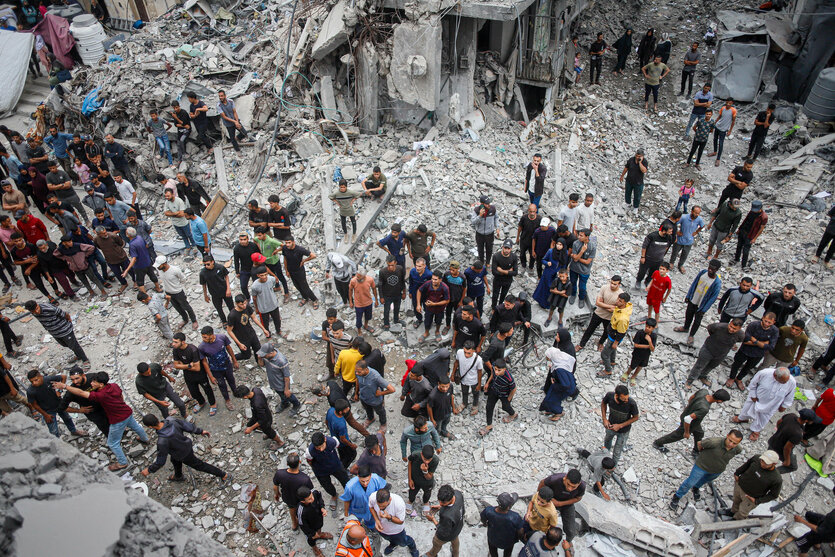 Menschen stehen in den Trümmern in Jabalia, Gaza