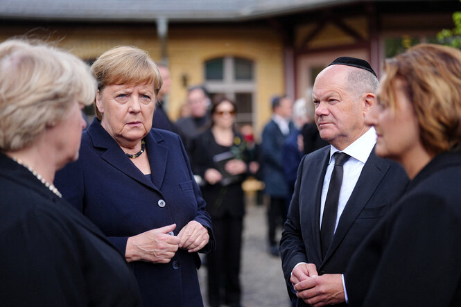 Vier Personen stehen als Gruppe zusammen und sprechen miteinander