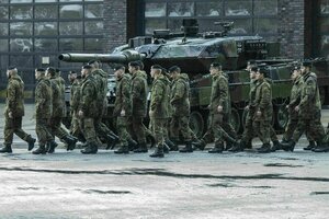Bundeswehrsoldaten marschieren an einem Kampfpanzer Leopard 2A6 vorbei