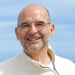 Ein Mann mit Brille kurzen Haaren und Pulli