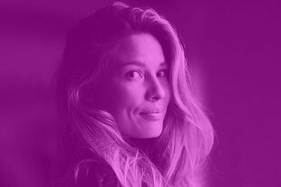 Porträtaufnahme von Martyna Linartas. Sie hat lange, wellige Haare, die leicht über die Schulter zur Kamera blickt. Ihr Gesichtsausdruck ist freundlich und selbstbewusst. Das gesamte Bild ist in einen kräftigen Magentaton eingefärbt, was der Markenfarbton des Dissens-Podcasts ist.
