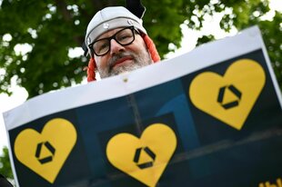 Mann mit Gallierhelm und Fahne mit gelben Herzen samt Commerzbank-Logo